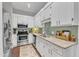 Stylish kitchen with white cabinets, stainless steel appliances, and green backsplash at 1304 Rothes Rd, Cary, NC 27511