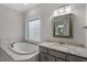 Elegant bathroom with soaking tub, gray vanity, and granite countertop at 1620 Dail Dr, Raleigh, NC 27603