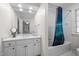 Clean bathroom with white vanity, bathtub, and blue shower curtain at 2035 Stuart Ct, Burlington, NC 27215