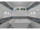 Modern bathroom with a standalone tub and tasteful tilework around built-in shelving and dual windows at 2035 Stuart Ct, Burlington, NC 27215