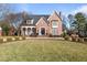 Two-story brick home with a manicured lawn and circular driveway at 2035 Stuart Ct, Burlington, NC 27215