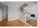 Bright foyer with hardwood floors, staircase with white railings, and views into the living room at 2035 Stuart Ct, Burlington, NC 27215