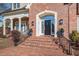 Elegant front entrance with brick steps, black door and black railings at 2035 Stuart Ct, Burlington, NC 27215