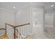 Upstairs hallway with a wooden banister and doorways to rooms including the bathroom at 2035 Stuart Ct, Burlington, NC 27215