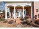 Brick porch with white columns, double doors, and comfortable seating at 2035 Stuart Ct, Burlington, NC 27215