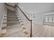 Carpeted staircase with wood railing adjacent to large living room with many windows at 2035 Stuart Ct, Burlington, NC 27215
