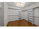 A walk-in closet with custom shelving and hanging racks, with a chandelier at 2035 Stuart Ct, Burlington, NC 27215