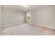 Bright bedroom with neutral carpet, one window, and a single ceiling light at 218 Strolling Way, Durham, NC 27707