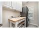 Convenient laundry room with front load washer and dryer, cabinets, and folding table at 218 Strolling Way, Durham, NC 27707