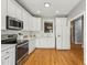 Bright kitchen with white cabinets, stainless appliances and a window over the sink at 235 Harbor Creek Dr, Cary, NC 27511