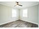 Bedroom featuring ceiling fan, wood-look flooring and abundant natural light from two windows at 2400 Dorety Pl, Raleigh, NC 27604