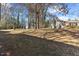 Partially visible backyard with mature trees and sparse ground cover at 2400 Keith Dr, Raleigh, NC 27610