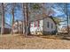 A view of the home's back exterior featuring mixed siding, windows with red shutters, and an AC unit at 2400 Keith Dr, Raleigh, NC 27610