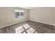 Bedroom with stylish wood-look floors, natural light from a large window, and neutral walls at 2400 Keith Dr, Raleigh, NC 27610