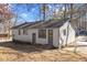 Back of house with gray siding and gray door to basement or utility room at 2400 Keith Dr, Raleigh, NC 27610