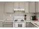 Close up view of the white stove with a view of the white cabinets and light countertops at 2400 Keith Dr, Raleigh, NC 27610