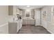 Traditional kitchen with white cabinets, white appliances and light countertops and wood look flooring at 2400 Keith Dr, Raleigh, NC 27610