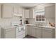 Traditional kitchen with white cabinets, white appliances and light countertops with a view of the sink area at 2400 Keith Dr, Raleigh, NC 27610