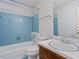 Traditional bathroom features a blue tiled tub and shower with complementary patterned wallpaper at 2509 Foxgate Dr, Raleigh, NC 27610