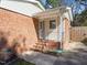 Cozy side entrance with brick steps and a small porch, providing convenient access at 2509 Foxgate Dr, Raleigh, NC 27610