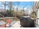 Wooden back deck with grill, outdoor table and chairs, and wooden railing overlooking a wooded backyard at 2612 Hiking Trl, Raleigh, NC 27615