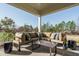 Relaxing covered porch with sectional sofa and coffee table, overlooking a tree-lined landscape at 3142 Armeria Dr, Apex, NC 27502