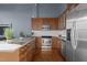 Modern kitchen with wood cabinets, granite counters, and stainless steel appliances at 500 N Duke St # 56-207, Durham, NC 27701