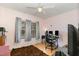 A bedroom with a ceiling fan, hardwood floors, and three windows that offer a view of the yard at 5141 Nc-39 N Hwy, Henderson, NC 27537