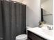 Clean bathroom with a vanity, toilet, and shower with dark gray curtain at 5238 Beardall St, Raleigh, NC 27616