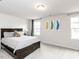 Bright bedroom with a plush bed, neutral colors, and decorative artwork on the wall at 5238 Beardall St, Raleigh, NC 27616