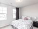 Inviting bedroom with floral bedding, two windows for plenty of light, and bedside table at 5238 Beardall St, Raleigh, NC 27616