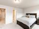 Neutral bedroom with a dark wood bed frame and a view into the hallway and closet space at 5238 Beardall St, Raleigh, NC 27616
