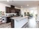 Bright, open kitchen with granite countertops, dark wood cabinets, and a dining area filled with plants at 5238 Beardall St, Raleigh, NC 27616