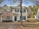 Two-story townhome with brick and white paneled siding, black shutters, and a welcoming front door at 5809 Neuse Wood Dr, Raleigh, NC 27616