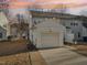 Rear view of townhome showcasing a detached garage and a small backyard at 5809 Neuse Wood Dr, Raleigh, NC 27616