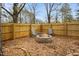 Cozy backyard with a stone fire pit, string lights, and wood privacy fence at 5920 Whittier Dr, Raleigh, NC 27609