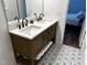 Bathroom with updated vanity, marble countertops, and decorative patterned floors at 5920 Whittier Dr, Raleigh, NC 27609