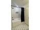 Bathroom with updated tub and shower featuring white subway tile and patterned floors at 5920 Whittier Dr, Raleigh, NC 27609