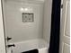 Bathroom with updated tub and shower featuring white subway tile and patterned floors at 5920 Whittier Dr, Raleigh, NC 27609