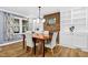 Bright dining room with modern lighting, exposed brick, built-in shelving and hardwood floors at 5920 Whittier Dr, Raleigh, NC 27609