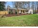 Charming brick and siding home with a well-manicured lawn and inviting front porch with yellow columns at 5920 Whittier Dr, Raleigh, NC 27609
