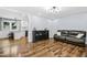 Open-concept living room with hardwood floors and neutral decor, with an adjoining kitchen at 5920 Whittier Dr, Raleigh, NC 27609