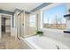 Spa-like bathroom with soaking tub, walk-in shower, and view at 6324 Fauvette Ln, Holly Springs, NC 27540