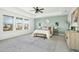 Main bedroom with a ceiling fan, large windows, and an ensuite bathroom at 6324 Fauvette Ln, Holly Springs, NC 27540