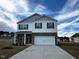 Two story house with gray siding, brick accents, and a two car garage at 7611 Michelle Rd, Rocky Mount, NC 27803