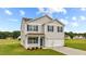 Two story house with beige siding, a two car garage, and landscaping at 7611 Michelle Rd, Rocky Mount, NC 27803