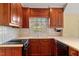 Kitchen features wood cabinets, white tile backsplash, and a window overlooking backyard at 806 E Franklin St, Chapel Hill, NC 27514
