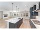 Modern kitchen featuring an island with quartz countertops, designer lighting, stainless appliances, and an open layout at 812 Abbyberry Dr, Wake Forest, NC 27587