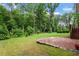 Spacious backyard with lush lawn, mature trees, and a brick patio at 1141 Barley Stone Way, Raleigh, NC 27603