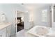 Bright bathroom featuring a soaking tub and an open doorway to the bedroom at 1141 Barley Stone Way, Raleigh, NC 27603